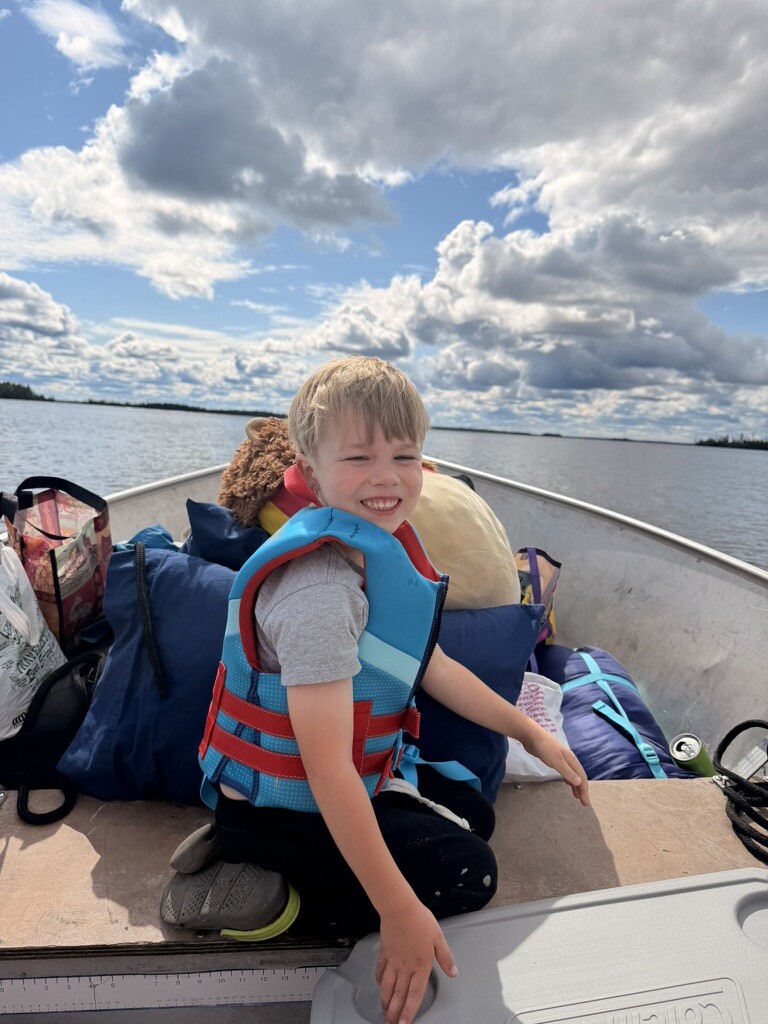Children in life jackets riding in the boat to Besnard Lake island