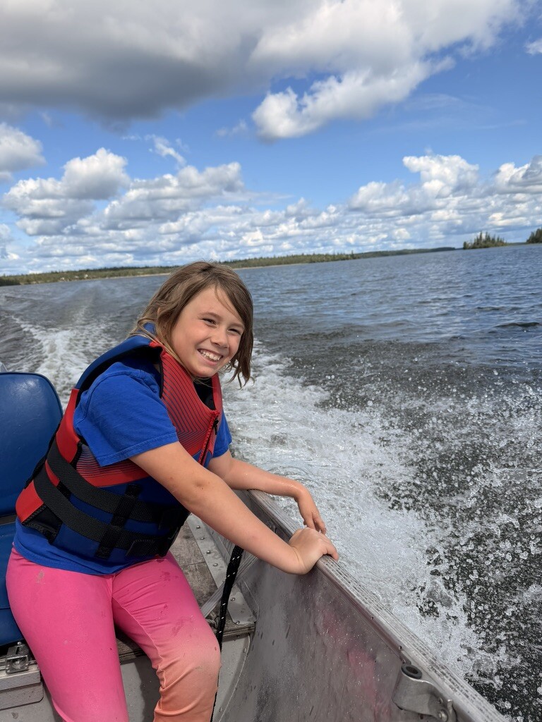 A child smiling from the boat during the crossing to the island