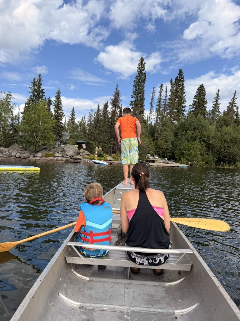 Family paddling a canoe around the island