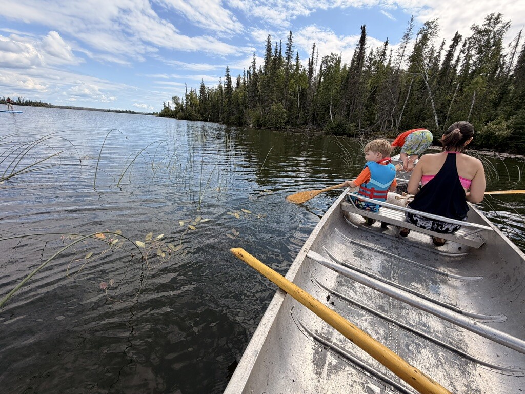Two canoes crossing the water beside Besnard Lake island
