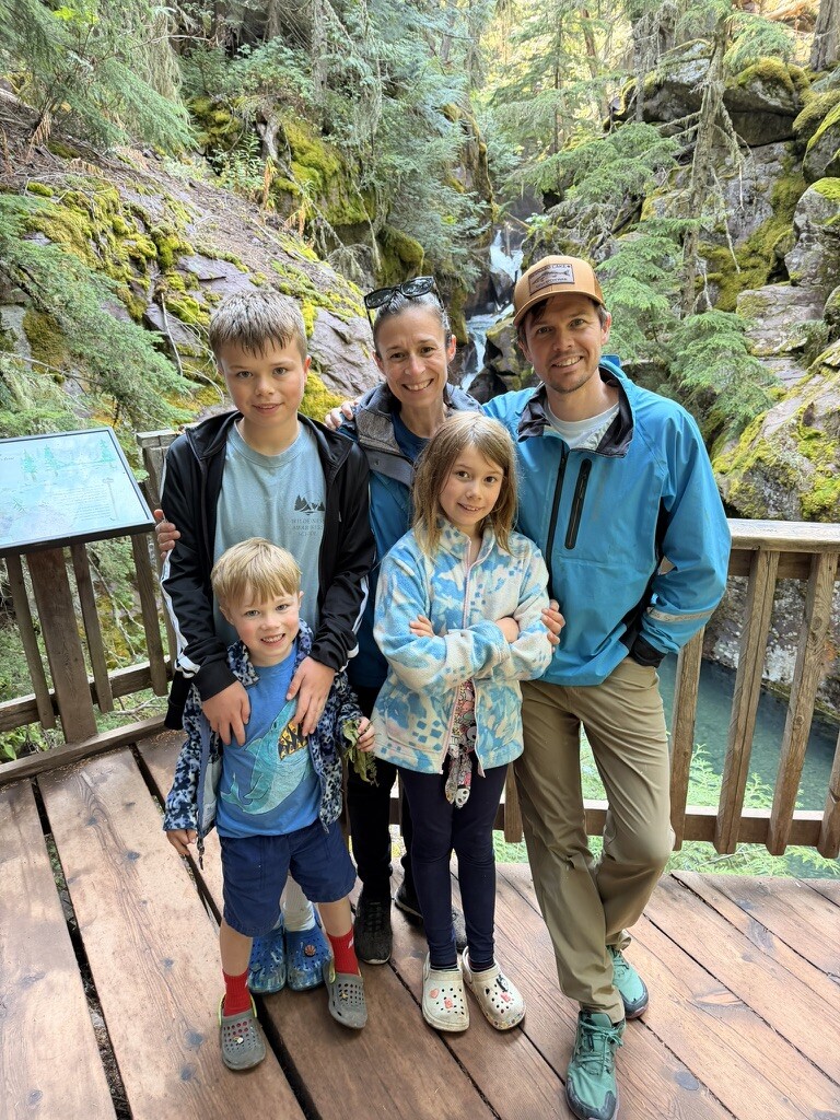 Family standing together among the cedars