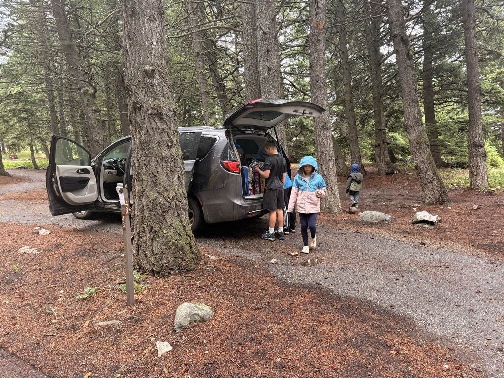 Family beside the van at Rising Sun Campground near the St. Mary entrance