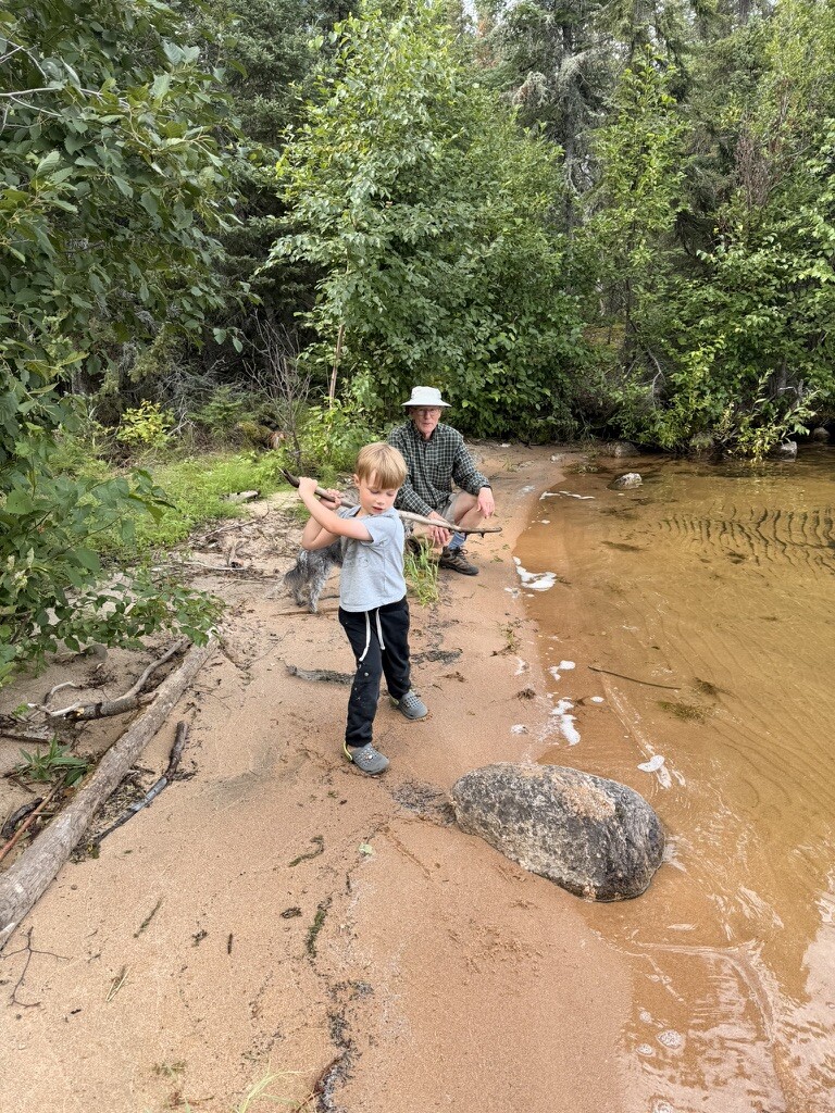 Douglas and Grandpa exploring a shallow beach on the island