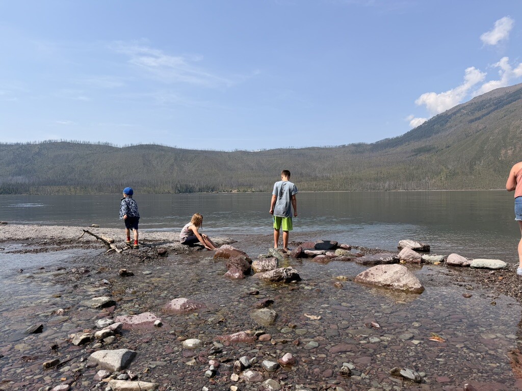 Children building small dams in the shallows of Lake McDonald