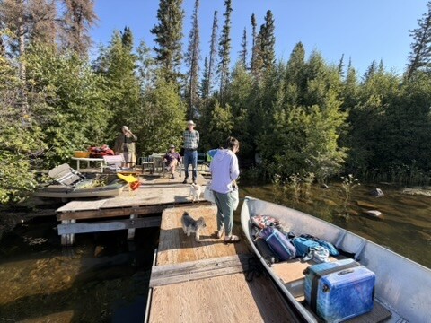 Family packing bags and supplies onto the boat at the dock
