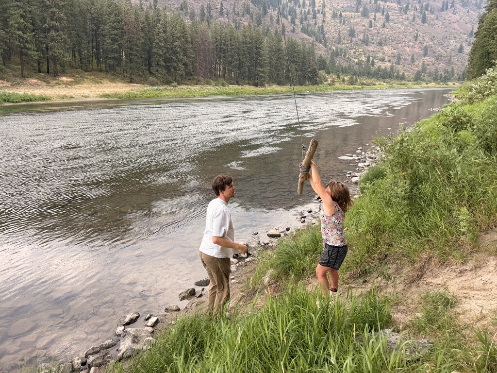 Family helping one another beside the river