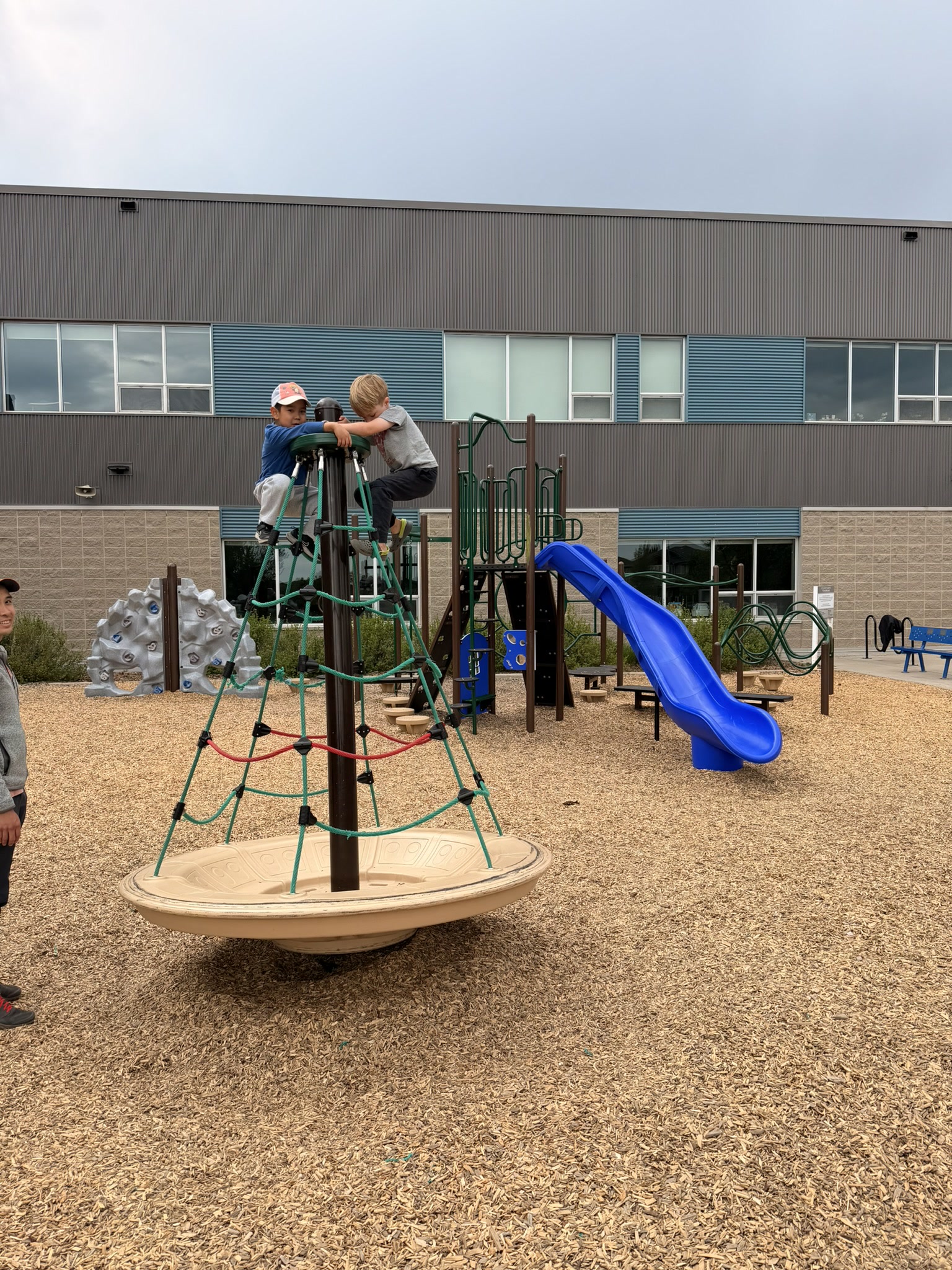 Douglas and Joshua playing together on a climbing structure in Saskatoon