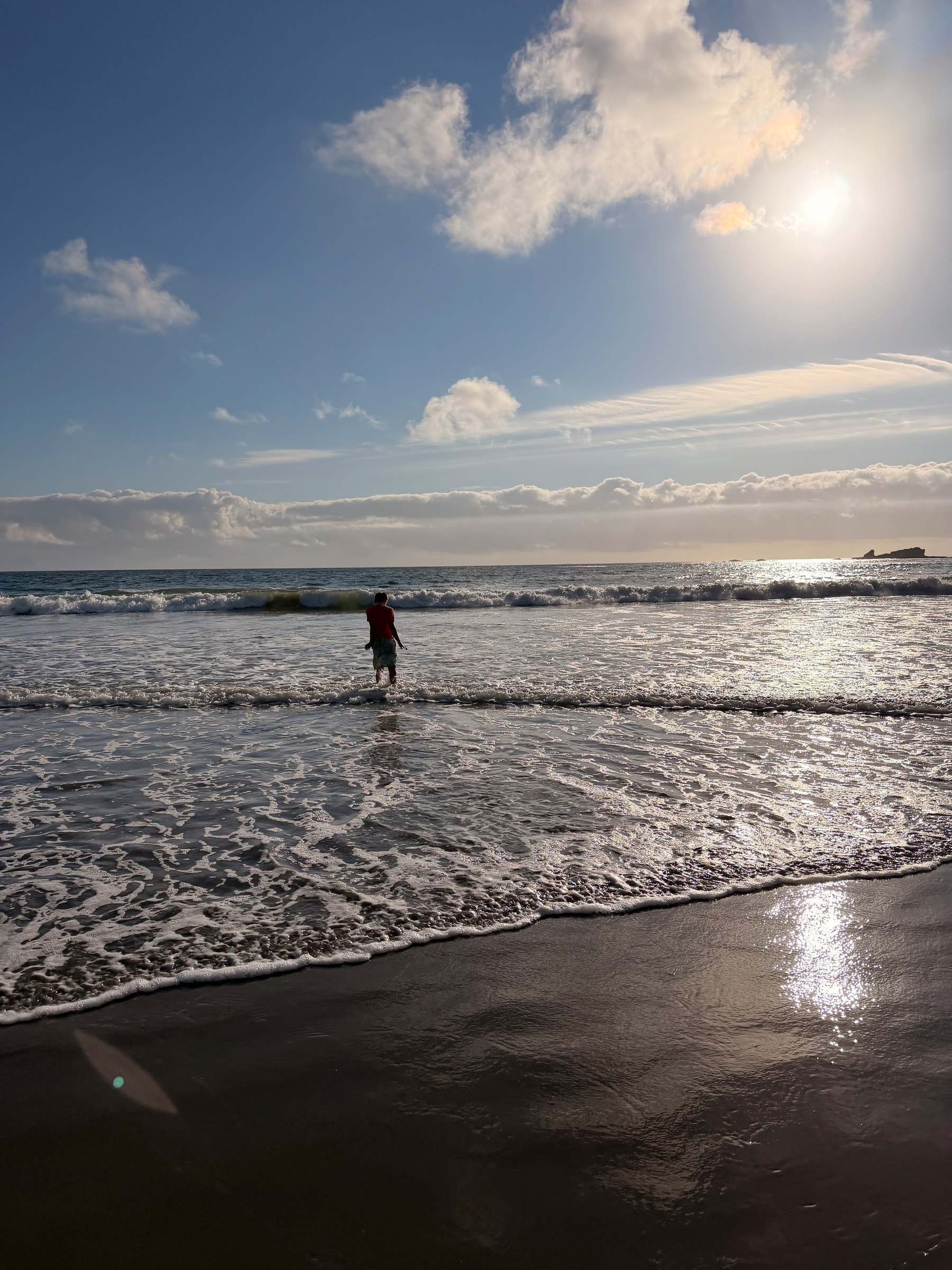 Birch wading into the Pacific surf in the evening light
