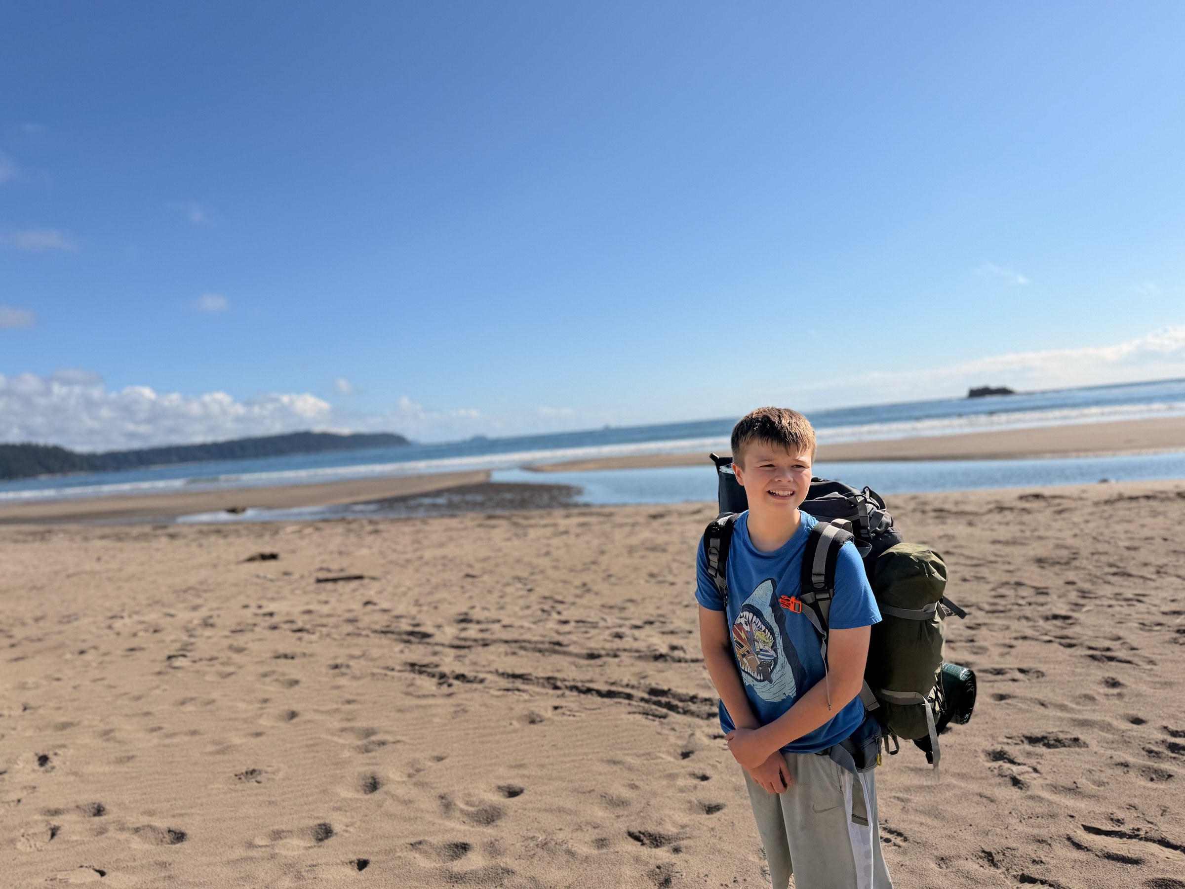 Birch walking along the beach with his large backpack