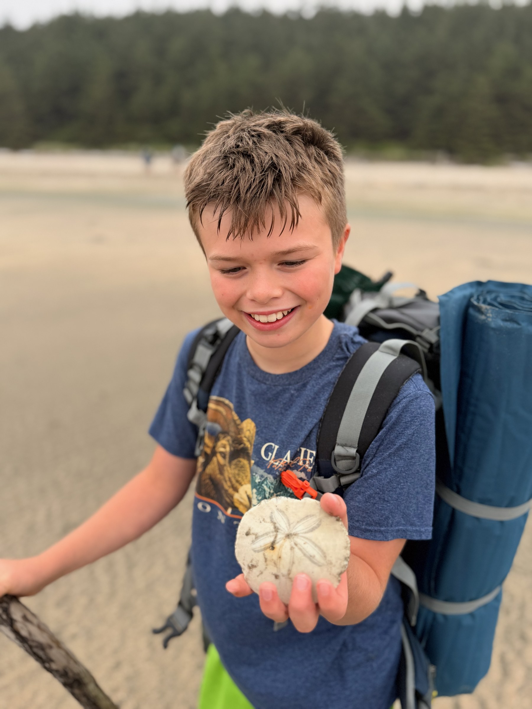 Birch smiling while holding a sand dollar