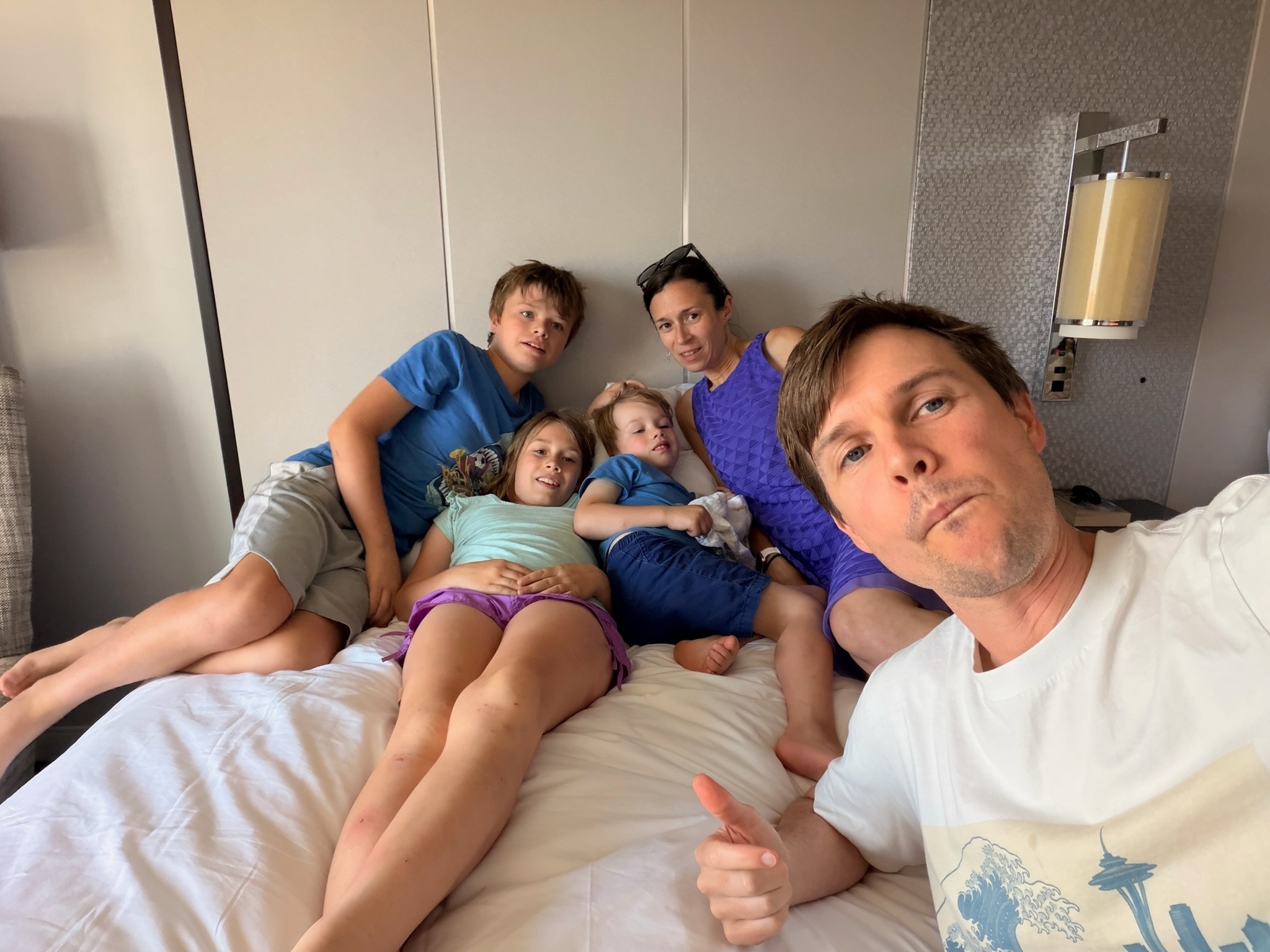 The family resting together on a hotel bed