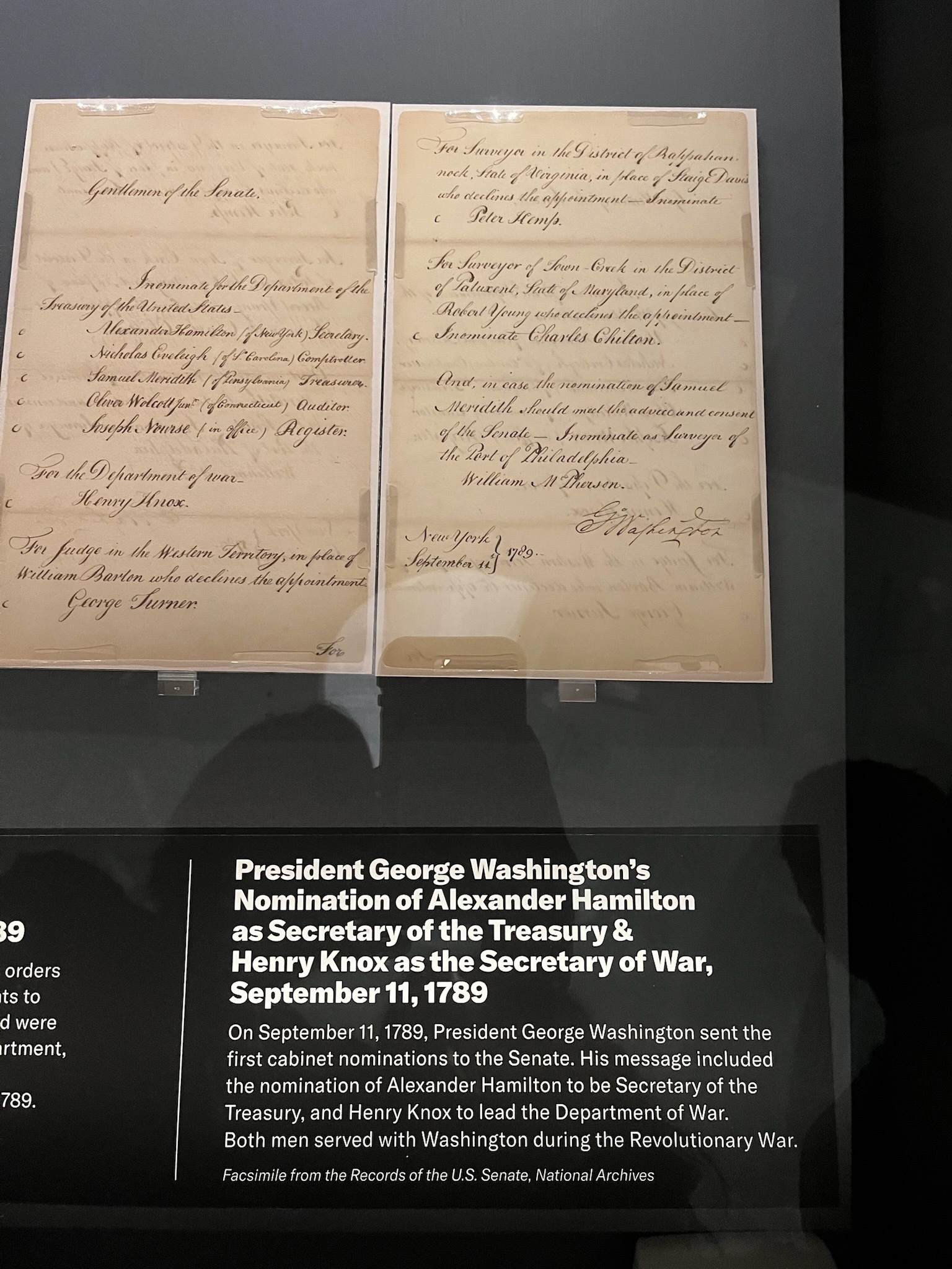 A historic handwritten document displayed at the National Archives