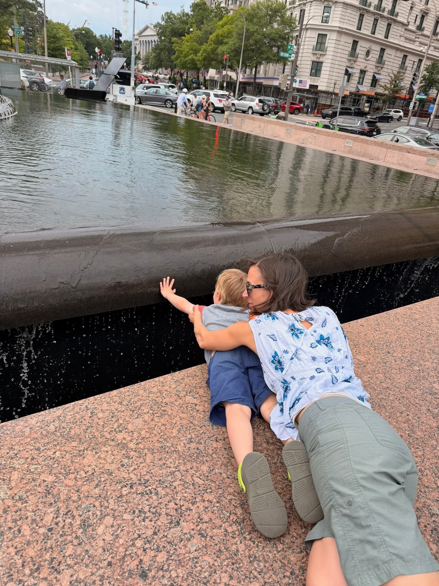 Stacey and Douglas leaning over a city fountain after the rain